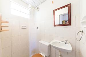 a white bathroom with a sink and a mirror at Hotel Econômico ao lado do Metrô in São Paulo