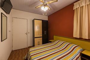 a bedroom with a bed and a ceiling fan at Hotel Econômico ao lado do Metrô in São Paulo