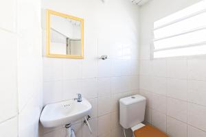 a bathroom with a sink and a toilet and a mirror at Hotel Econômico ao lado do Metrô in São Paulo
