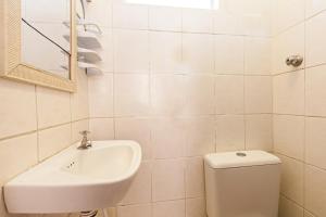 a white bathroom with a sink and a toilet at Hotel Econômico ao lado do Metrô in São Paulo