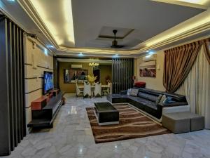 een woonkamer met een bank en een televisie bij RIA Homestay in Johor Bahru