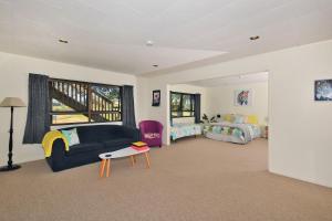 uma sala de estar com um sofá, uma cama e uma mesa em Ridge Haven Accommodation em Ruakaka