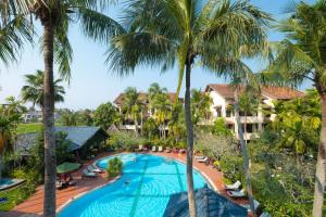 
a beach with a pool, chairs, and trees at Hoi An Trails Resort & Spa in Hoi An
