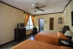 a bedroom with two beds and a ceiling fan at Tierra Magica B&B and Art Studio in San José