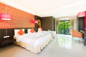 een slaapkamer met 2 bedden en een balkon met bij Prelude Hotel in Kanchanaburi