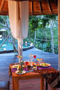 une table avec des assiettes de nourriture et des verres à vin dans l'établissement Ayurvedagram Bali, à Ubud