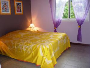 a yellow bed in a room with a window at Les Gites De Robinson in Conception