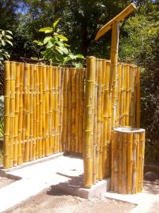 Ein Bambus-Zaun mit Mülltonne daneben. in der Unterkunft Hostal El Balsamo in El Sunzal