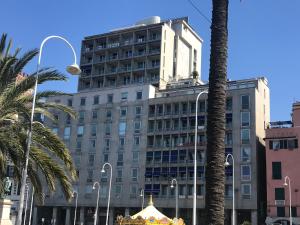 a tall building with a palm tree in front of it at Bluripa Guest House in Genoa