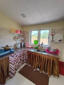 a kitchen with a counter with a sink and a window at villa tempoyak homestay in Pantai Cenang