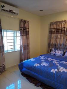 Un dormitorio con una cama azul con cortinas y una ventana en villa tempoyak homestay, en Pantai Cenang