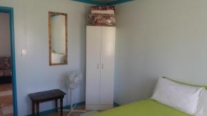 sypialnia z łóżkiem, stołem i lustrem w obiekcie Aitutaki Budget Accommodation w mieście Amuri