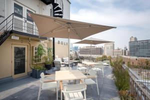 a patio with tables and chairs and umbrellas on a building at THE BOLY OSAKA in Osaka