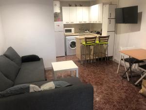a living room with a couch and a table and a kitchen at Roman Circus views Apartment in Tarragona