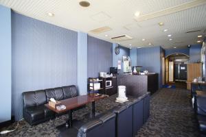 a waiting room with a leather couch and a table at Hotel Free Style in Kofu