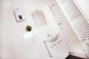 een witte badkamer met een wastafel en een spiegel bij Ferienwohnung BECKENDORF in Losheim