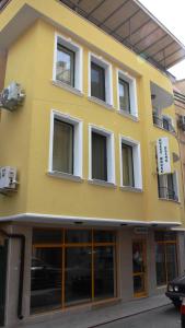 un edificio amarillo con ventanas laterales en Guest House Elit en Burgas