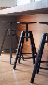 un tavolo in legno con due sgabelli sotto un tavolo di Penthouse Apartments Ana a Sutivan (San Giovanni di Brazza)