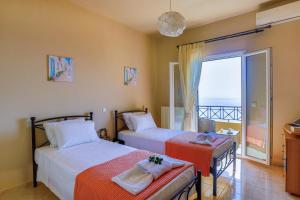 two beds in a room with a view of the ocean at Villa Dimeli in Barbati