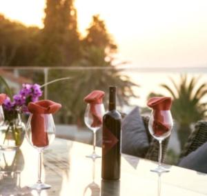 una bottiglia di vino seduta su un tavolo con bicchieri da vino di Penthouse Apartments Ana a Sutivan (San Giovanni di Brazza)