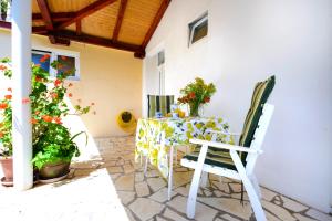 a table and chairs on a patio with flowers at Oreb Dream Apartments in Koločep