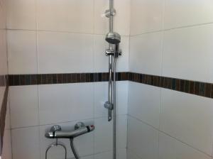 y baño con ducha y azulejos blancos. en Le Castel du Cros, en Cagnes-sur-Mer