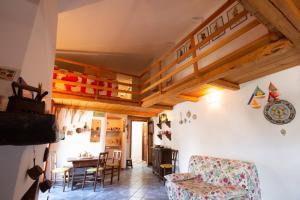 uma sala de estar com tectos em madeira e uma mesa e cadeiras em Cosy loft - Loft di atmosfera in Sperlonga alta em Sperlonga