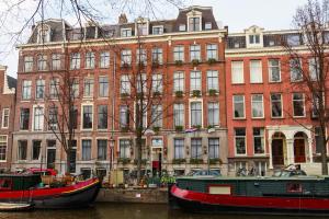 zwei Boote im Wasser vor einem Gebäude in der Unterkunft Prinsengracht Hotel in Amsterdam