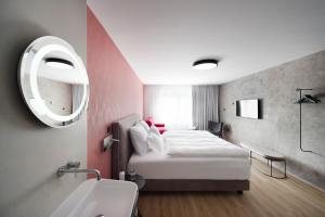 Un dormitorio con una cama, un lavabo y un espejo. en ibis Styles Ljubljana Centre, en Liubliana