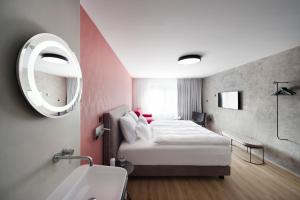 a hotel room with a bed and a mirror at Central Hotel Superior in Ljubljana