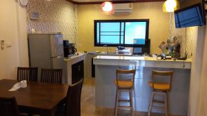 a kitchen with a counter and a table and a kitchen with a sink at Honchana house in Ban Bang Po