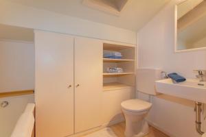 a white bathroom with a toilet and a sink at Gästehaus Rosi in Fieberbrunn