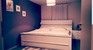 a bedroom with a white bed with a blue wall at Gasthof L'italiano Vero in Bad Liebenzell