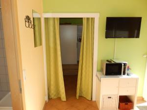 アールベックにあるBungalow (hälfte) Backbord Ahlbeck (Usedom)の黄色いカーテンと電子レンジが備わる客室です。