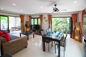 ein Wohnzimmer mit einem Tisch und einem Sofa in der Unterkunft Baan Santhiya Private Pool Villas - FREE Tuk-Tuk Service to the Beach! in Ao Nang Beach