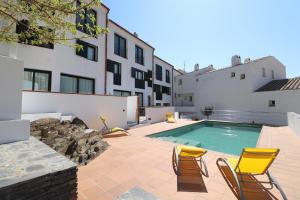 un patio avec des chaises et une piscine dans l'établissement Cadaqués Masnou Apartaments, à Cadaqués
