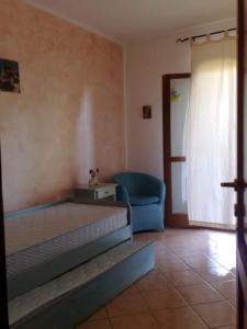 a bedroom with a bed and a blue chair at Honey's little house in Palau