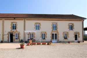 a large white building with a courtyard in front of it at La Janenquelle in Sarry