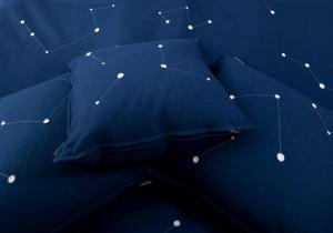 a blue comforter with constellations on it at Treehotel in Harads
