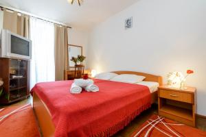 a bedroom with a bed with towels on a red blanket at Oreb Dream Apartments in Koločep