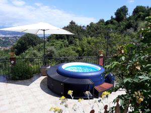 a hot tub sitting on a patio with an umbrella at Lo Chalet sul Golfo in La Spezia