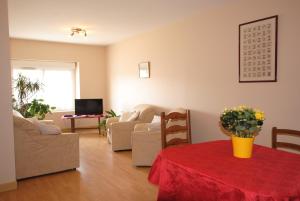 een woonkamer met een tafel met een rode tafelkleed bij La Janenquelle in Sarry