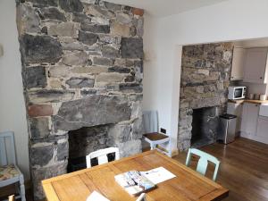 a dining room with a table and a stone wall at Pen-y-Patch in Prestatyn