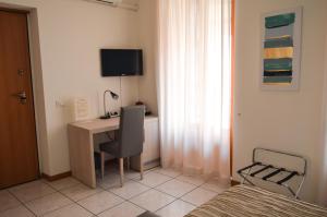 a bedroom with a desk with a computer and a bed at La Contrada in Sarnico