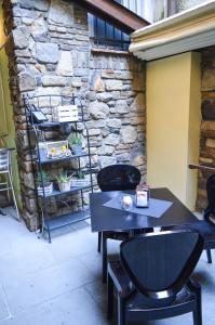 a table and chairs in front of a stone wall at La Contrada in Sarnico