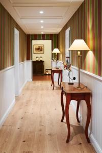 a hallway with a table with a lamp on it at Relais & Châteaux Hardenberg BurgHotel in Nörten-Hardenberg