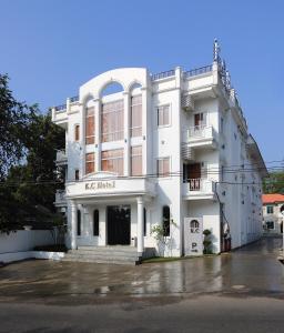 un edificio bianco con un cartello sulla parte anteriore di K.C Hotel a Yangon