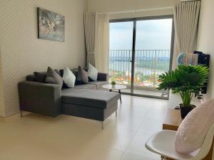 a living room with a couch and a large window at MRT Apartment In Masteri Thao Dien in Ho Chi Minh City