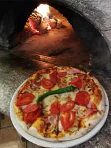 una pizza en un plato en un horno de pizza en Pensiunea San Gennaro, en Miercurea-Ciuc