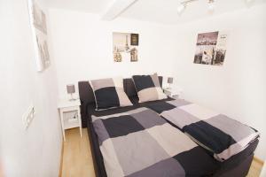 a bedroom with a bed with a striped blanket at Ferienwohnung BECKENDORF in Losheim